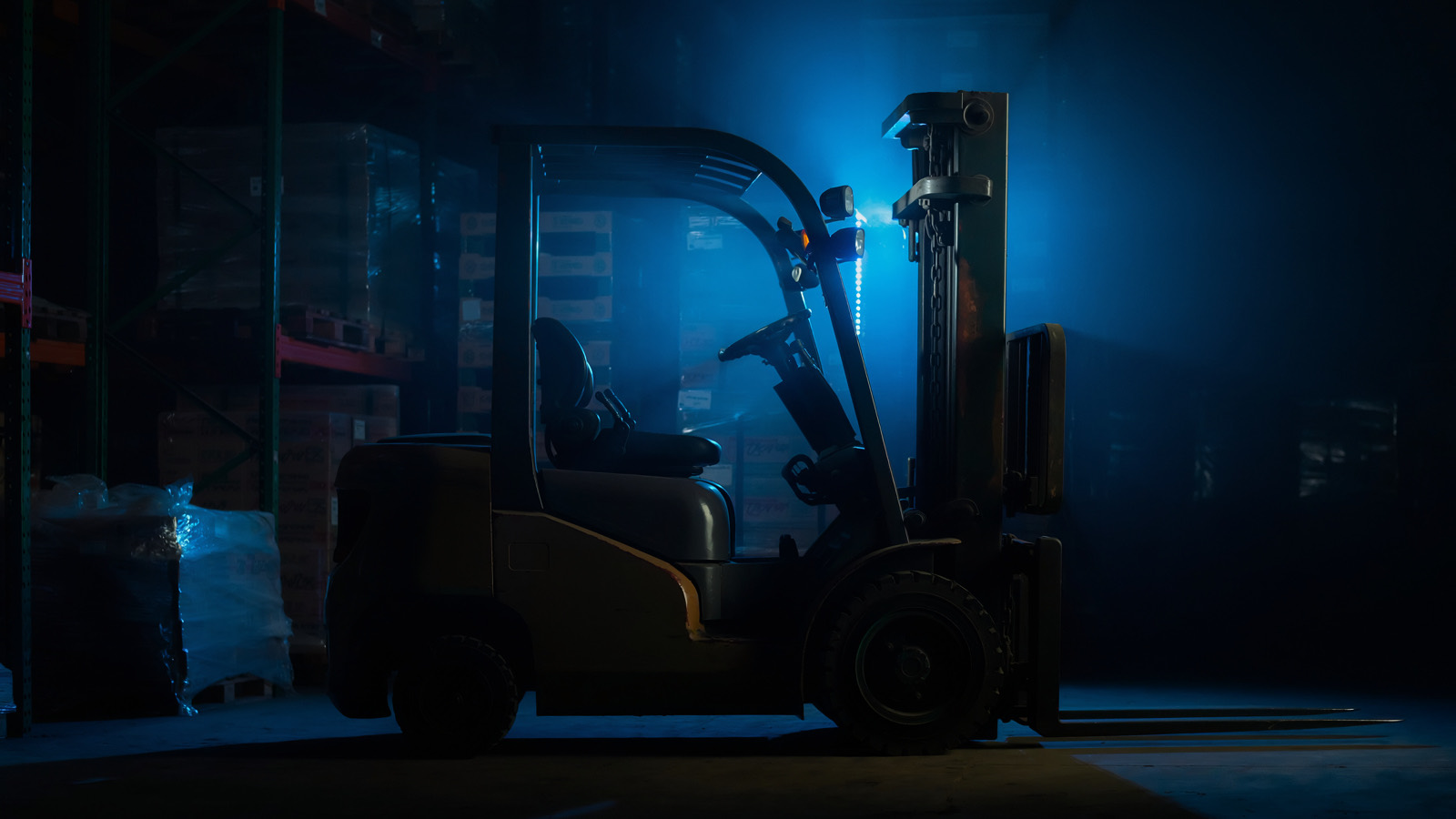 Forklift in a dark warehouse with blue accent lighting, representing financed equipment and the state tax impact of Section 179 decoupling